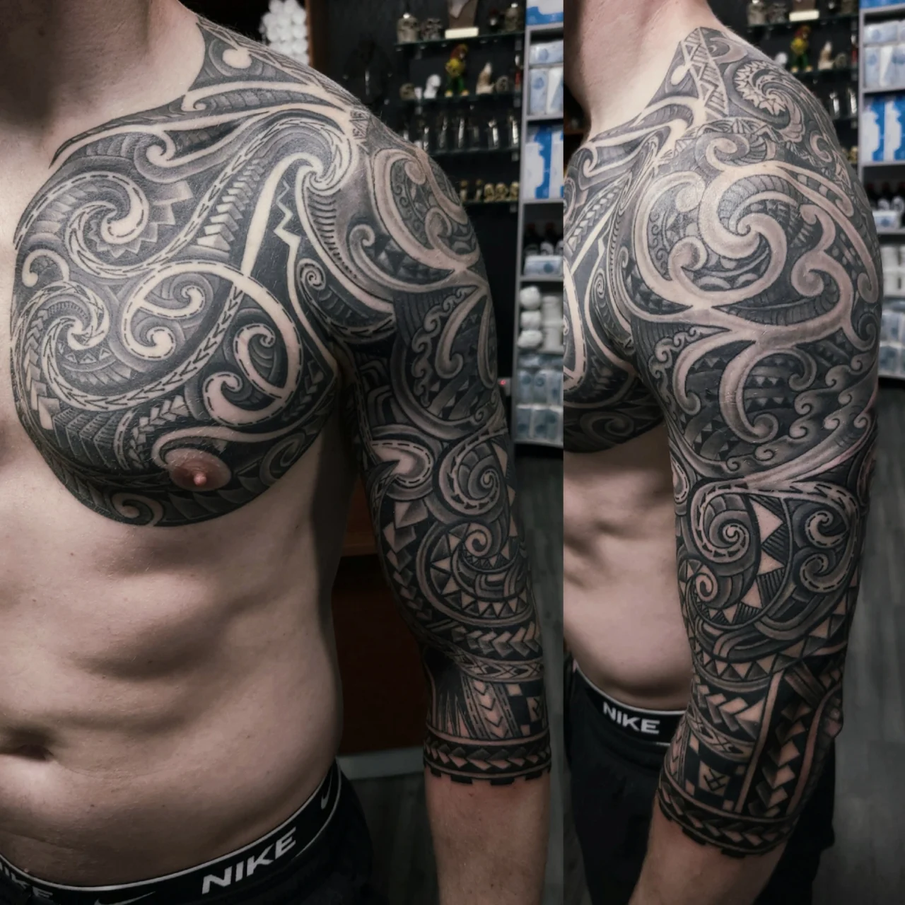 A muscular man with detailed black and grey Polynesian tribal tattoos covering his shoulder, chest, and upper arm. The tattoos feature bold geometric patterns, swirls, and intricate linework.