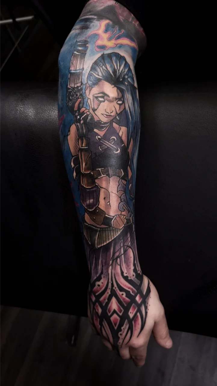 A forearm tattoo depicting a stylized female character with long blue hair, holding a gun, wearing a cropped top and gloves, with decorative abstract patterns extending toward the wrist.
