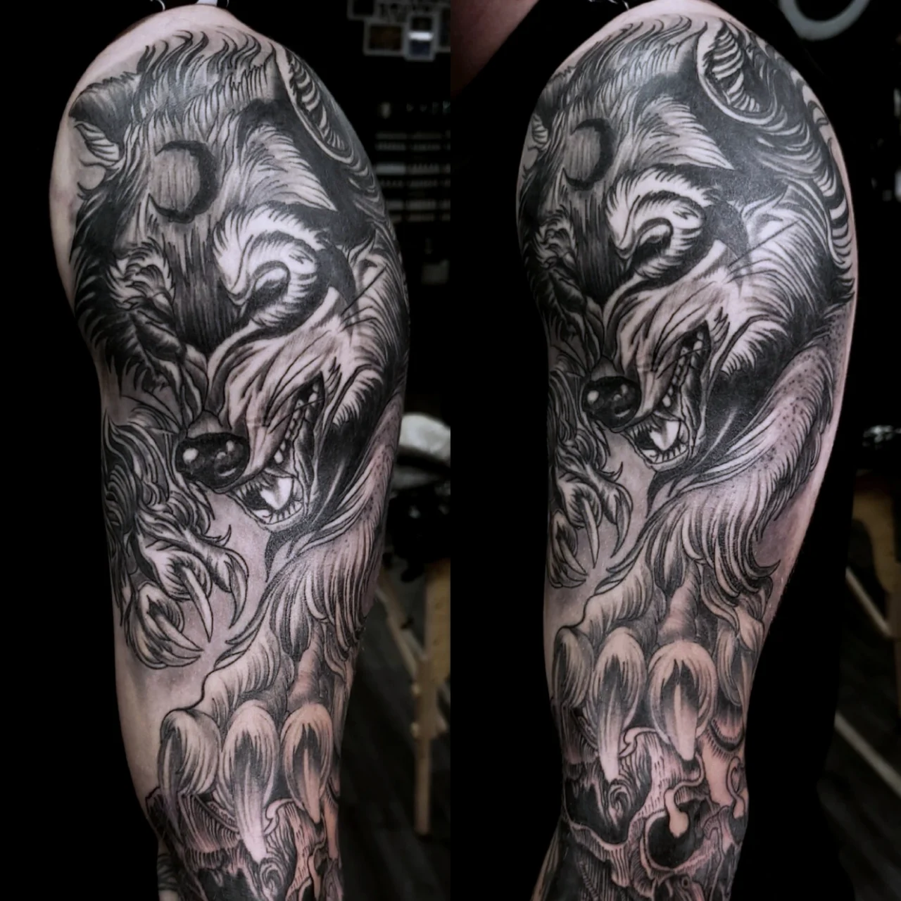 A detailed black and gray tattoo of a snarling wolf with bared teeth and prominent claws, covering a persons upper arm and shoulder. The design features intricate shading and swirling fur patterns.