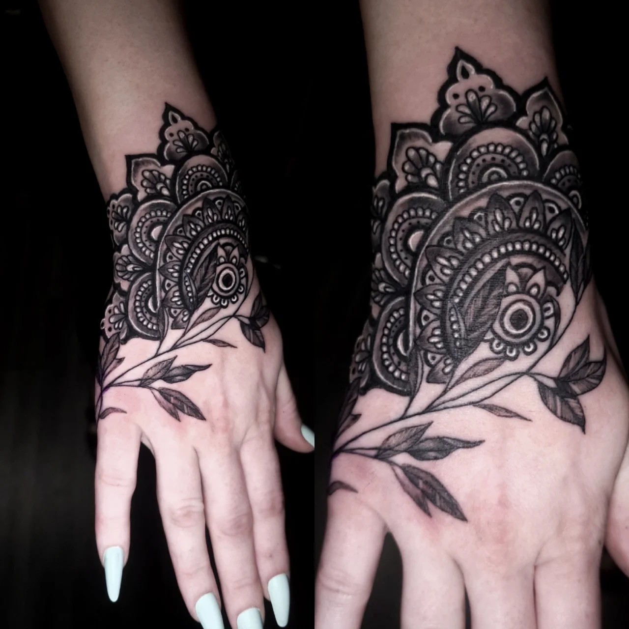 A black ink mandala-style tattoo with intricate patterns and leafy branches covers the top of a person’s hand, extending slightly up the fingers and wrist. The person has long, pale blue nails.
